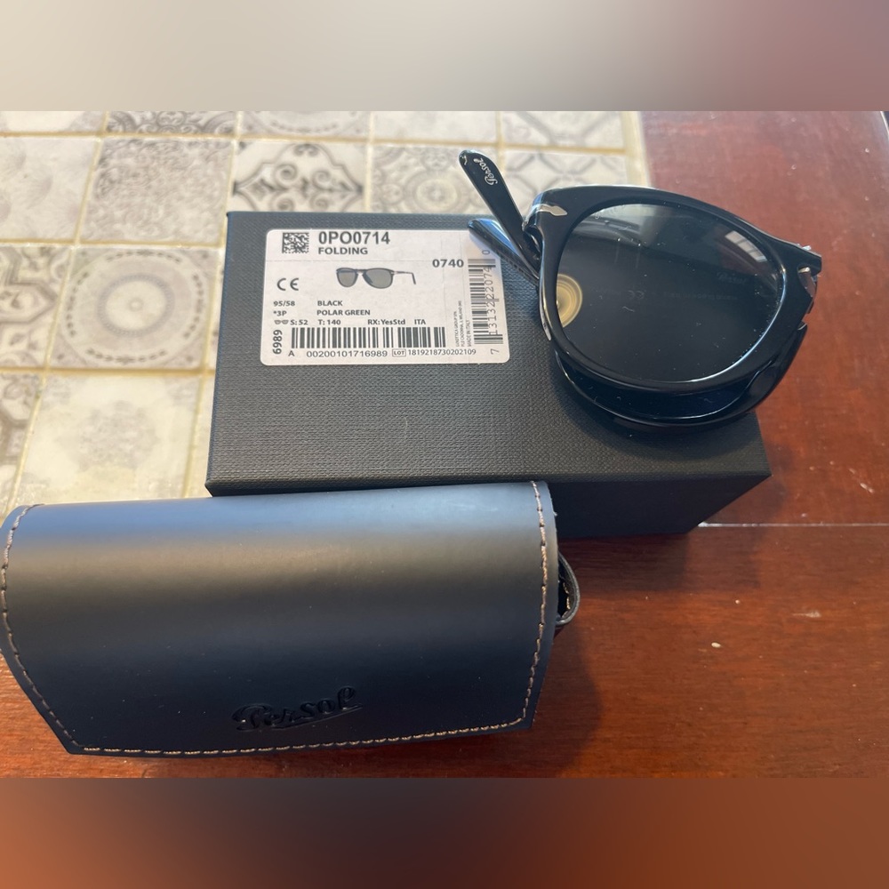 Unisex Persol 714 Folding Sunglasses. Black frame with polarized green lenses.